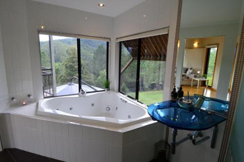 a bath tub in a bathroom with a large window at EcOasis in Uki