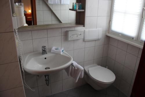 uma casa de banho com um lavatório e um WC em Hotel Guter Tropfen em Hagnau