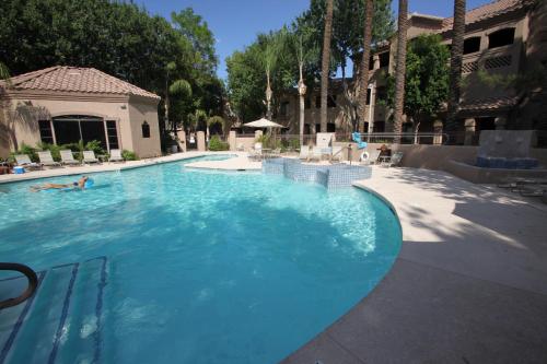 a large blue swimming pool with people in it at Villa Signature in Scottsdale