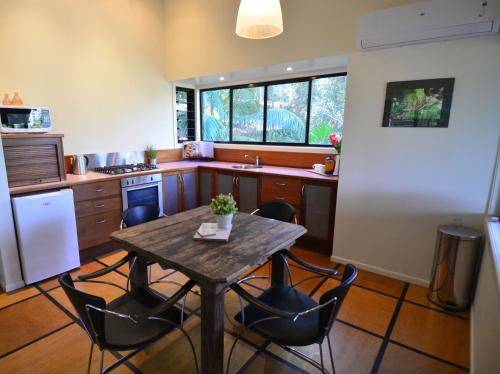 a kitchen with a wooden table and chairs in a kitchen at EcOasis in Uki