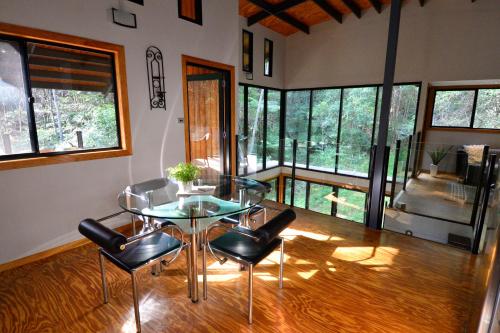 a dining room with a glass table and chairs at EcOasis in Uki