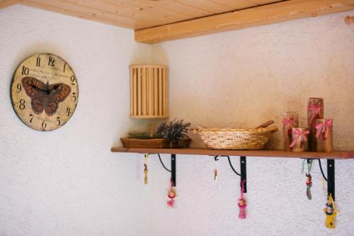 a clock on a wall next to a shelf at Cosy Chalet on Pokljuka - Brunarica Tinkara in Zgornje Gorje