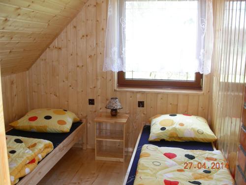 a bedroom with two beds and a window in it at Choszczogród in Sierakowice