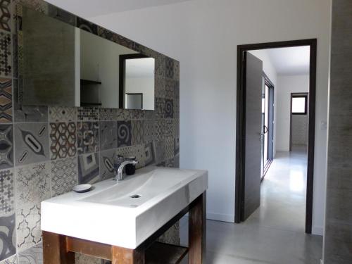 a bathroom with a white sink and a mirror at Villa piscine Sud France in Verzeille