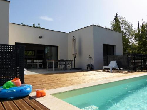 a house with a swimming pool and a wooden deck at Villa piscine Sud France in Verzeille