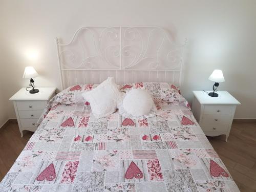 - une chambre avec un lit doté d'une couette rose et blanche dans l'établissement Villa Venus Woods, à Martina Franca