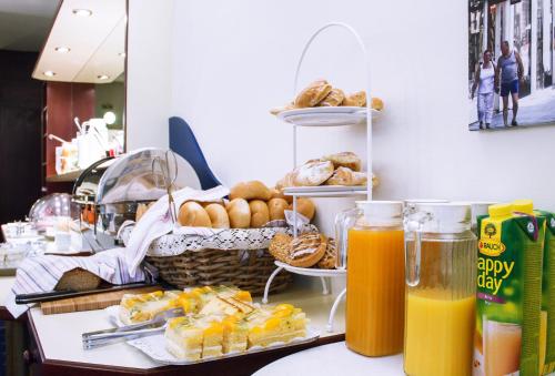 a table with a basket of bread and orange juice at Pension Pharmador in Vienna