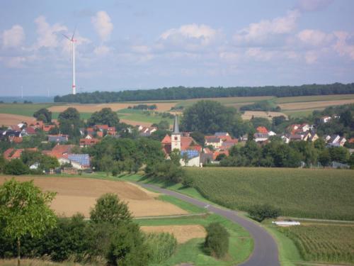 a small village with a windmill in the distance at Ferienwohnung Wilpert in Schwanfeld