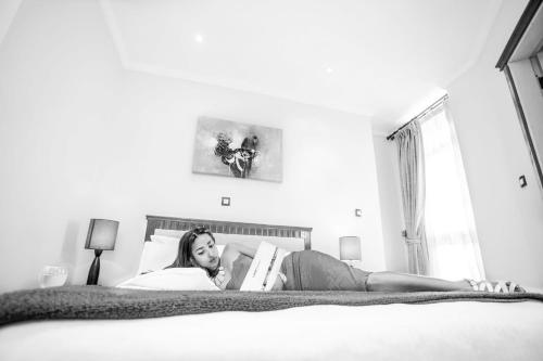 a woman laying on a bed reading a book at Stay Easy Hotel in Addis Ababa