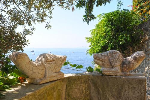 two stone statues on a wall overlooking the ocean at Villa Pietra Santa in Positano