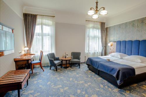 Habitación de hotel con cama, escritorio y sillas en Hotel Diament Plaza Gliwice, en Gliwice