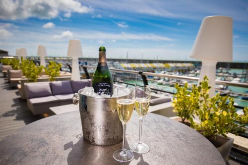 Una botella de champán y dos copas en una mesa. en Malmaison Brighton en Brighton & Hove