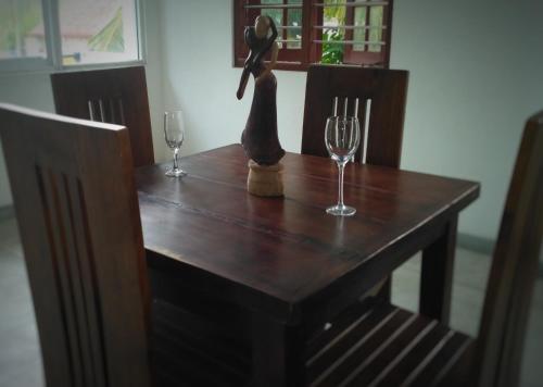 una mesa de madera con dos copas de vino. en Kith Fiesta Villa, en Hikkaduwa