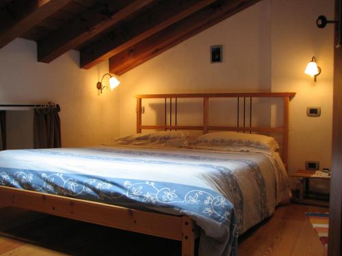 1 dormitorio con 1 cama grande con marco de madera en B&B Vecchio Torchio, en Bard