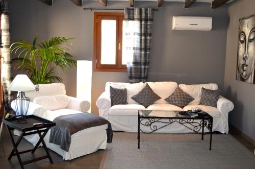 een woonkamer met een witte bank en een tafel bij Edificio duplex Can Roses in Moscari
