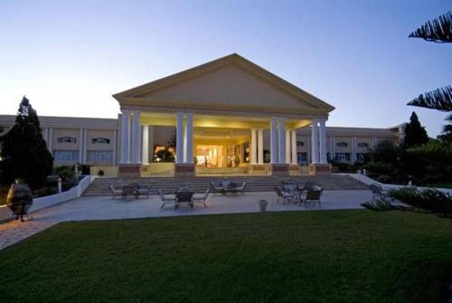 a building with benches and tables in a park at Royal Thalassa Monastir in Monastir