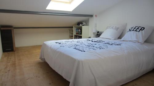 - une chambre avec un grand lit blanc et des draps blancs dans l'établissement Studio A Grans, à Grans