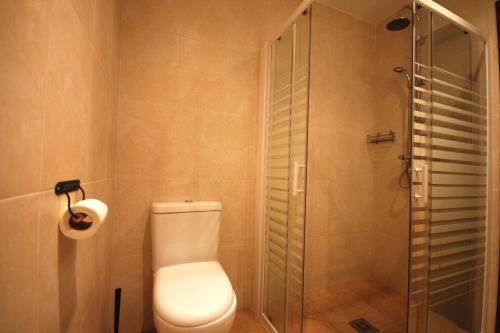 une salle de bain avec toilettes et douche en verre dans l'établissement Lets Holidays COZY APARTMENT 70 m. from THE BEACH in TOSSA, à Tossa de Mar