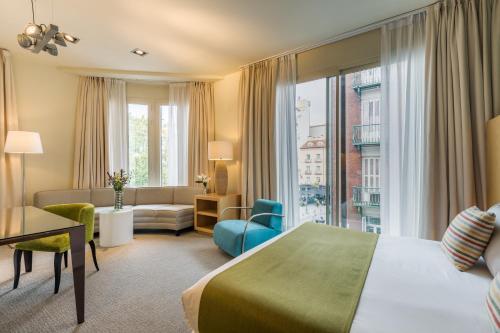 a hotel room with a bed and a living room at Room Mate Alicia, Madrid in Madrid