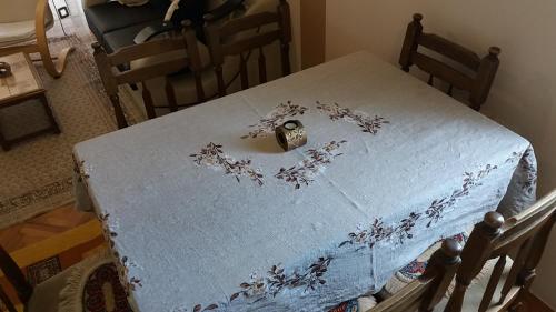 a table with a white table cloth with flowers on it at Apartments "Predah kod Baraća" in Niš