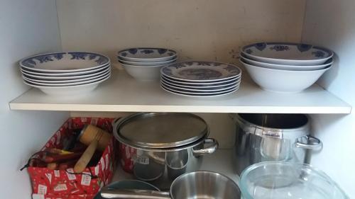 a shelf with bowls and plates on it at Apartments "Predah kod Baraća" in Niš