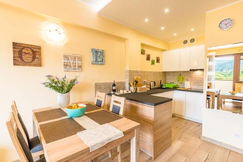 a kitchen with a wooden table and a dining room at Apartament Sweet Home in Krynica Zdrój