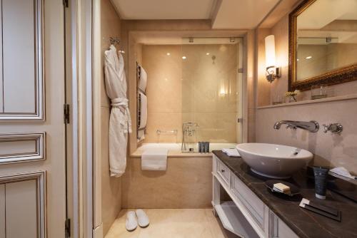 a bathroom with a sink and a tub and a mirror at Michlifen Resort & Golf in Ifrane