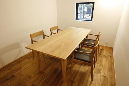 a wooden table and chairs in a room at Yamagata The Takinami in Nanyo