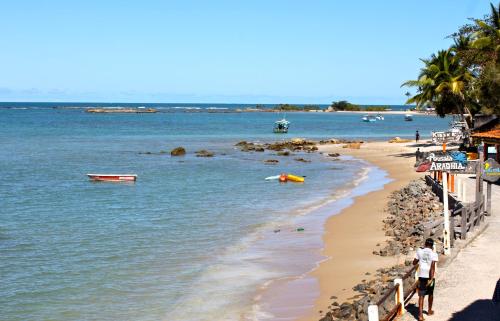 a beach with boats in the water next to a beach at Pousada Tranquila in Morro de São Paulo