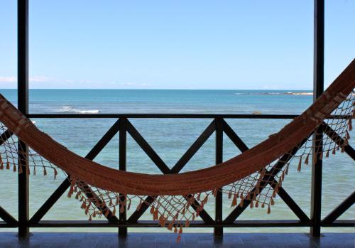 a hammock in front of the ocean at Pousada Tranquila in Morro de São Paulo