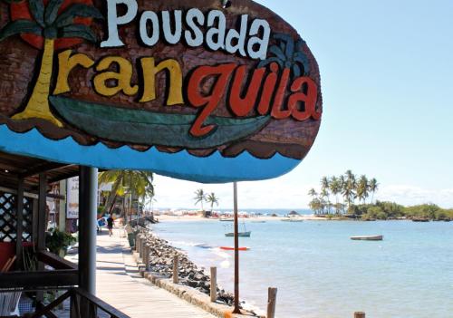 a sign for a restaurant next to a beach at Pousada Tranquila in Morro de São Paulo