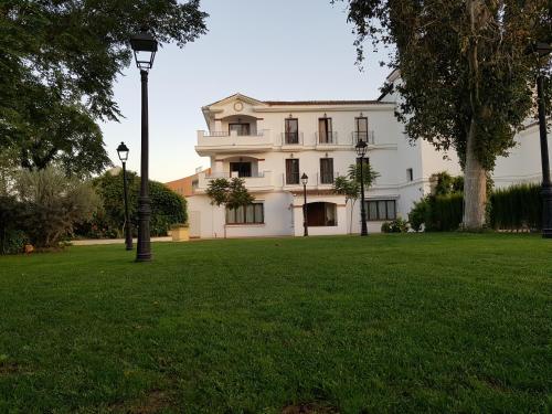 a large white building with a green lawn at Los Dólmenes in Antequera