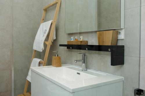 Un baño con un lavabo blanco y un espejo. en Atlantis, en Antananarivo