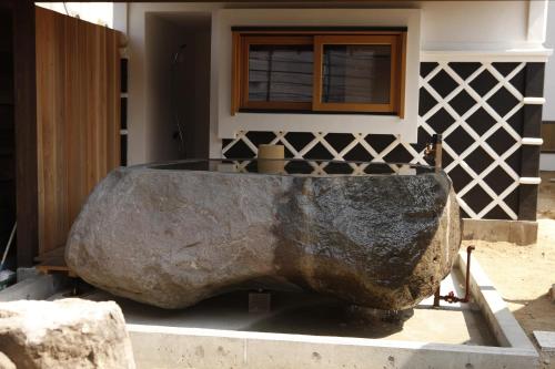a large stone tub sitting in front of a house at Yamagata The Takinami in Nanyo