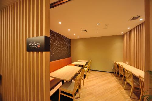 a row of tables and chairs in a restaurant at Dormy Inn Express Meguro Aobadai Hot Spring in Tokyo