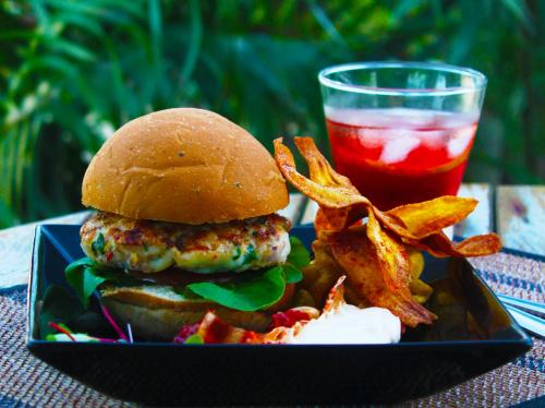 a plate with a burger and french fries and a drink at Pousada Vila Araticum in Santo André
