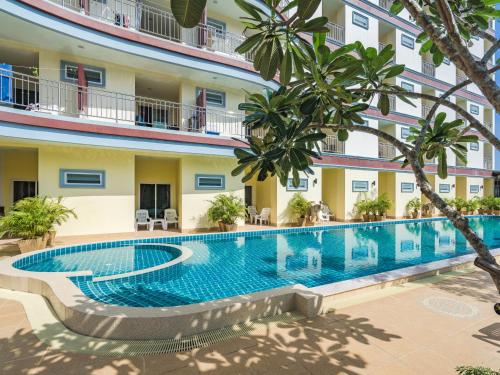 a swimming pool in the courtyard of a hotel with trees at Smile Residence in Rawai Beach