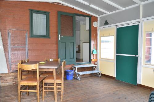 埃多洛的住宿－阿達梅洛露營地，门廊配有桌椅和房屋