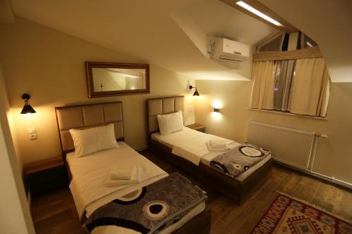a small room with two beds and a mirror at Saray Hotel in Prizren