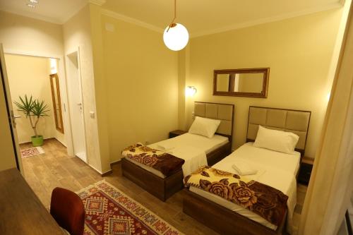 a hotel room with two beds and a mirror at Saray Hotel in Prizren