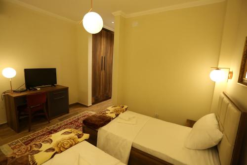 a hotel room with two beds and a television at Saray Hotel in Prizren