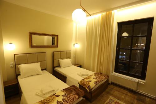 a small room with two beds and a window at Saray Hotel in Prizren