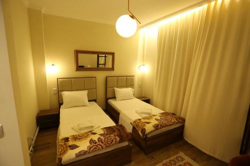 a small room with two beds and a mirror at Saray Hotel in Prizren