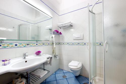 ein Bad mit einem Waschbecken, einem WC und einer Dusche in der Unterkunft Hotel Zi' Teresa in Sorrent