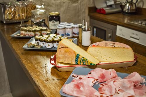 a table with cheese and meat on a counter at Maison La Saxe in Courmayeur