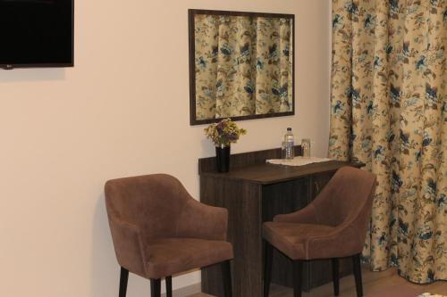 a room with two chairs and a sink and a mirror at Non-stop hotel in Boryspilʼ