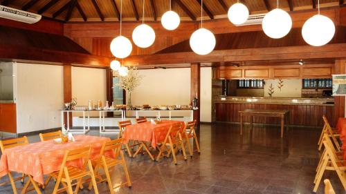 a dining room with tables and chairs and lights at Ceta Ecotel in Macapá