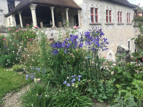 a garden with purple flowers in front of a building at Demeure des Vieux Bains in Provins