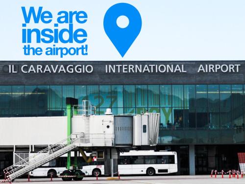 a bus is parked in front of an airport at Resting Pods - ZZZleepandGo BGY Airport in Orio al Serio