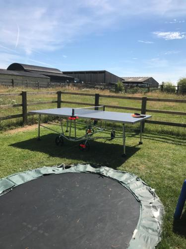 a ping pong table sitting on top of a field at Rew Farm Country & Equestrian Accommodation - Sunrise Lodge in Melksham